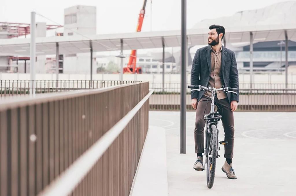 homem de bike olhando por cima de uma ponte