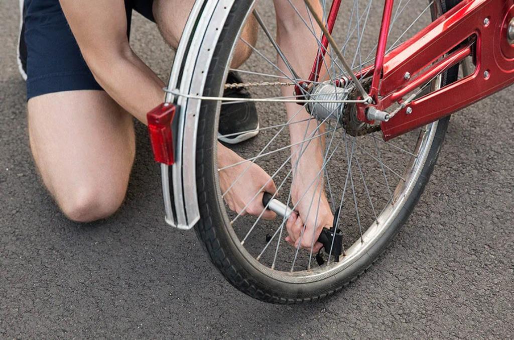 Pessoa enchendo pneu de uma bicicleta vermelha