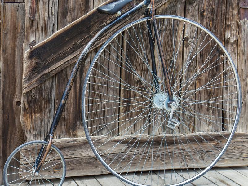 Imagem de uma bicicleta antiga onde a roda dianteira era maiordo que a traseira
