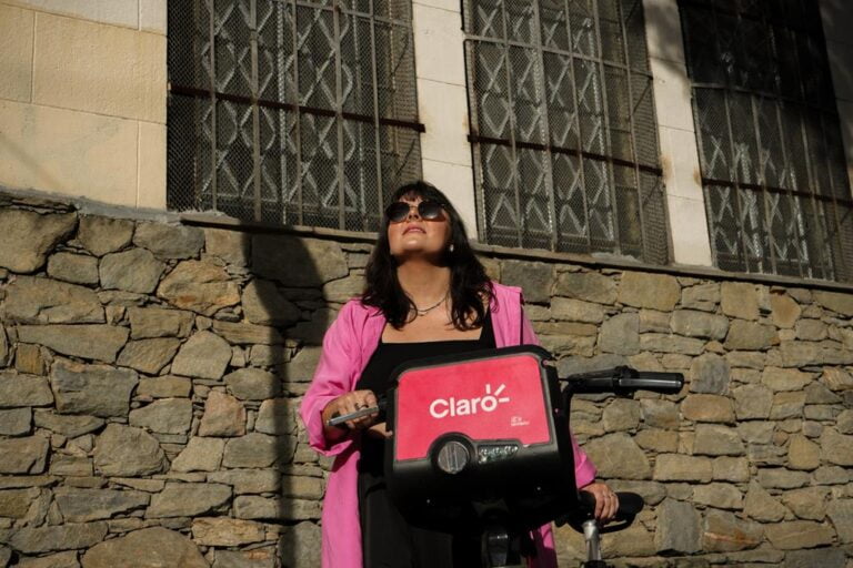 mulher sorrindo ao sol com uma bike da tembici