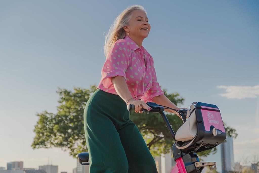 mulher usando bike da tembici, e desfrutando dos benefícios de pedalar
