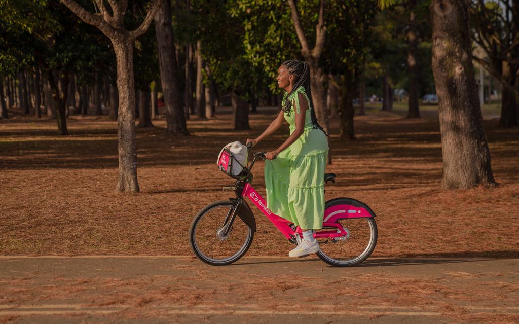 mulher usando bike da Tembici em um parque