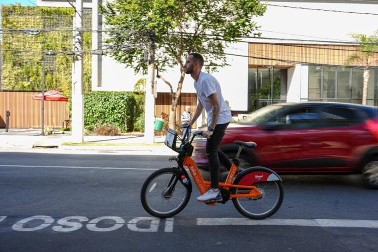 homem andando com bicicleta da tembici em são paulo