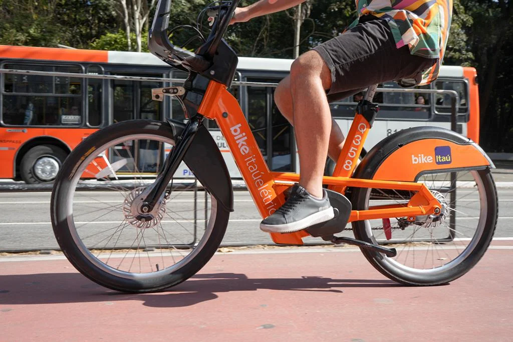 jovem andando de bike elétrica itaú na cidade de São Paulo