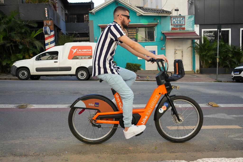 homem andando com uma bike elétrica Itaú.