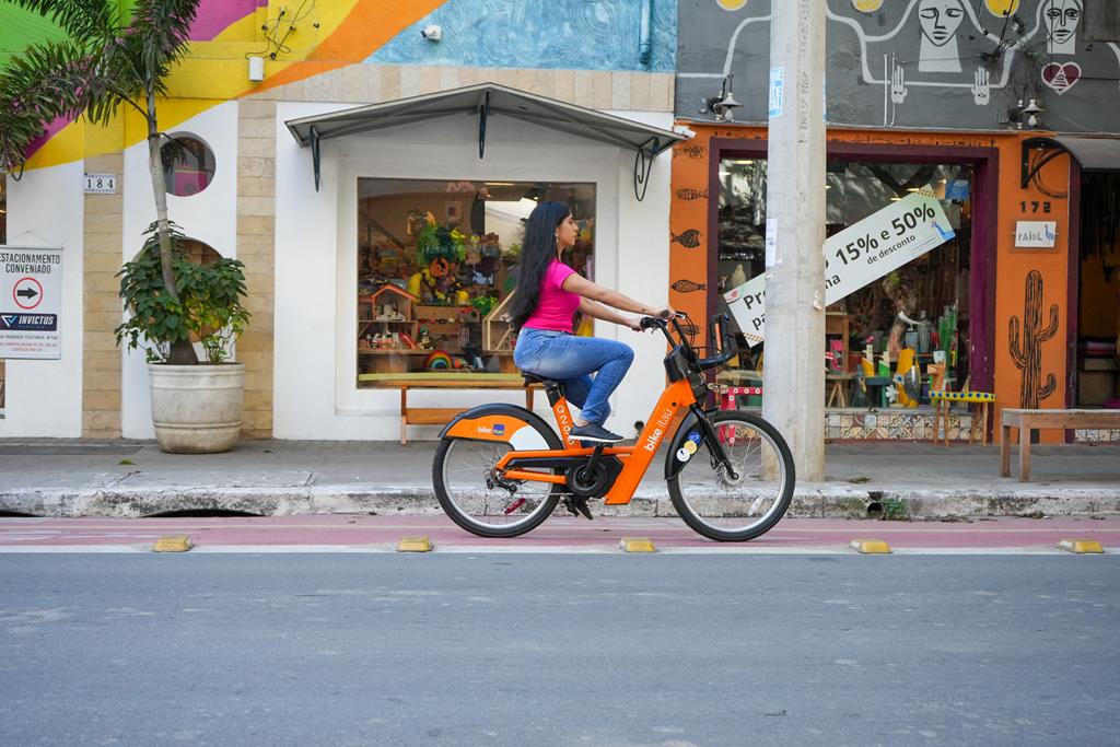 mulher pedalando em bike na ciclovia