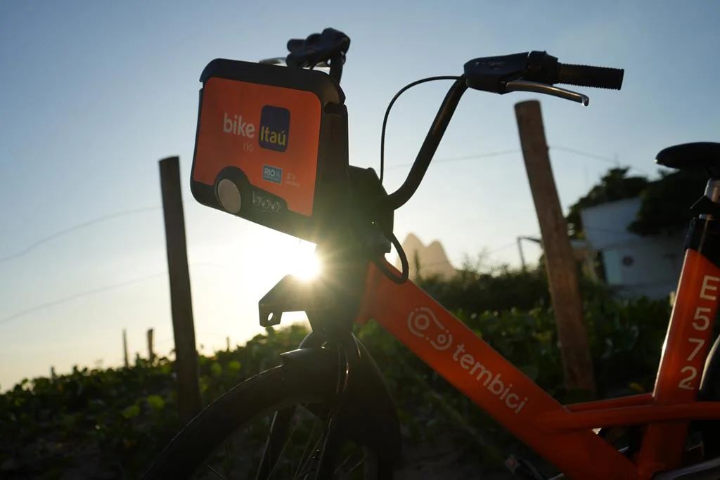 bike tembici estacionada próximo de uma cerca com vegetação.