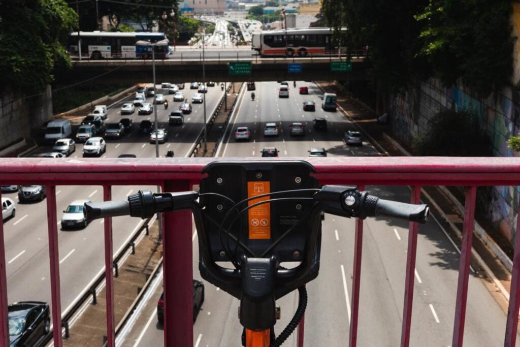 Bike da Tembici em viaduto de São Paulo mostrando o transito da cidade.