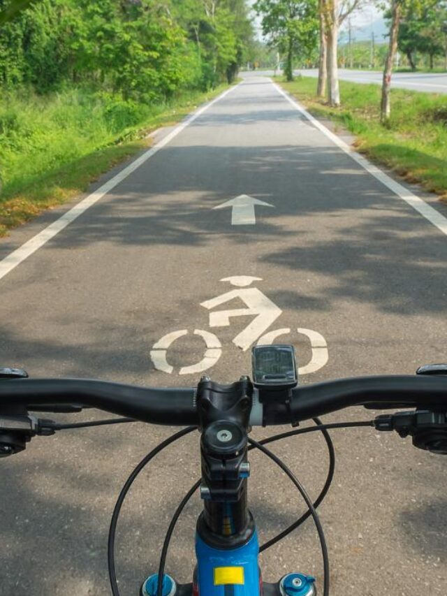 Visão em primeira pessoa do guidão da bike e uma ciclovia a sua frente