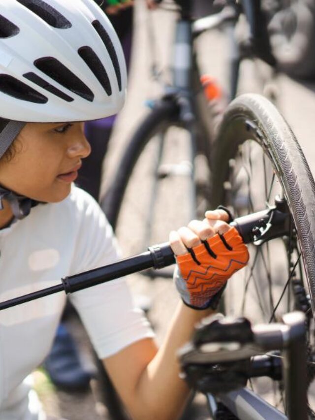 mulher enchendo pneu de bicicleta com bomba manual