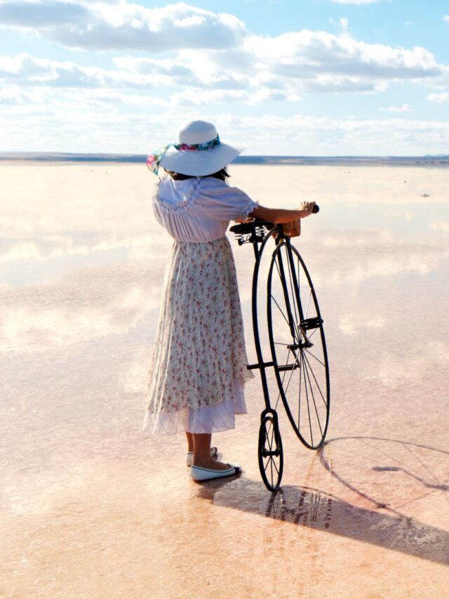 uma mulher com seu biciclo em uma bela paisagem