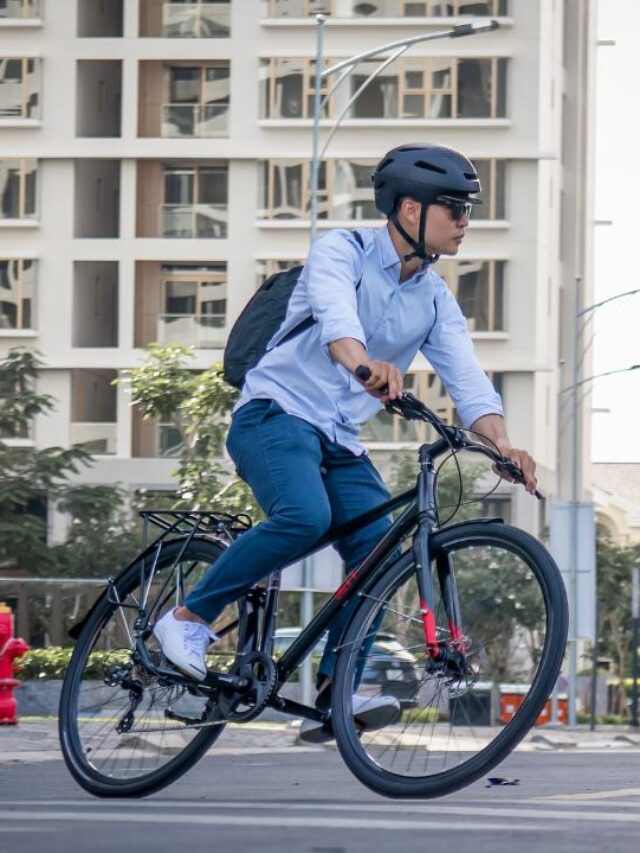 homem andando de bicicleta na cidade, usando capacete de proteção