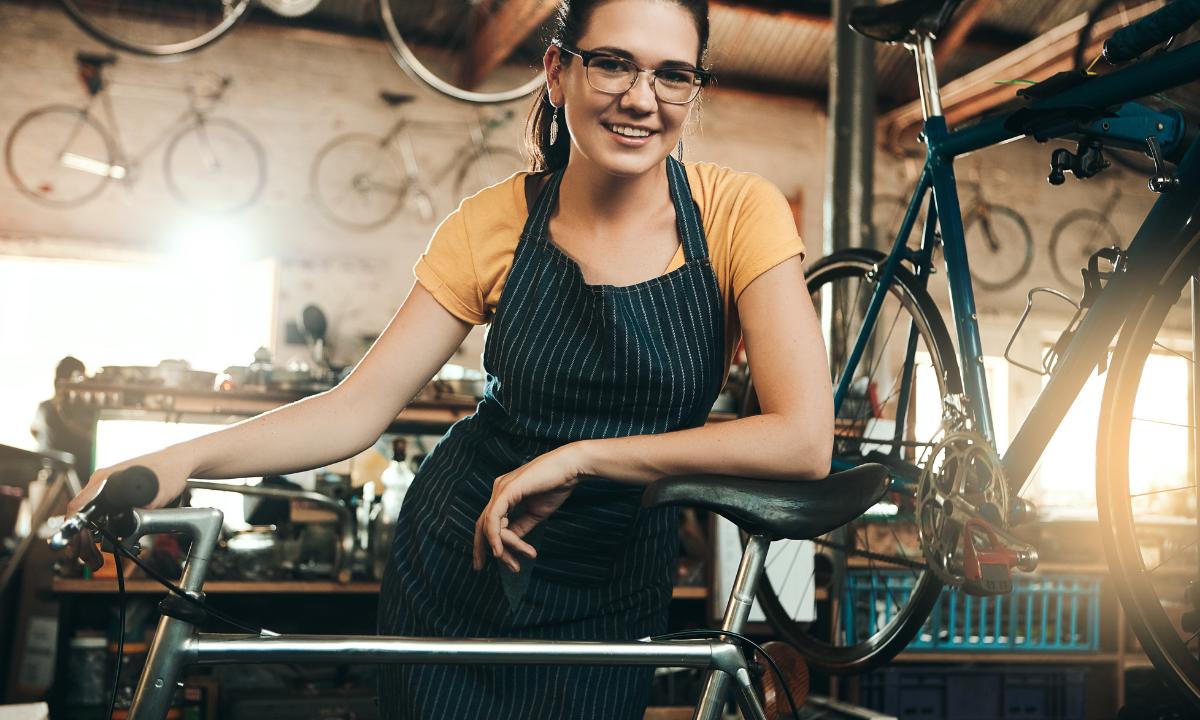 Muher em sua oficinas para bicicletas, dando dicas de tamanho ideal para bicicleta