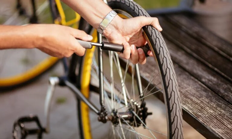 homem enchendo pneu da bicicleta com bomba manual pequena