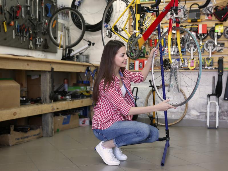 mulher mexendo em uma bicicleta em uma oficina especializada