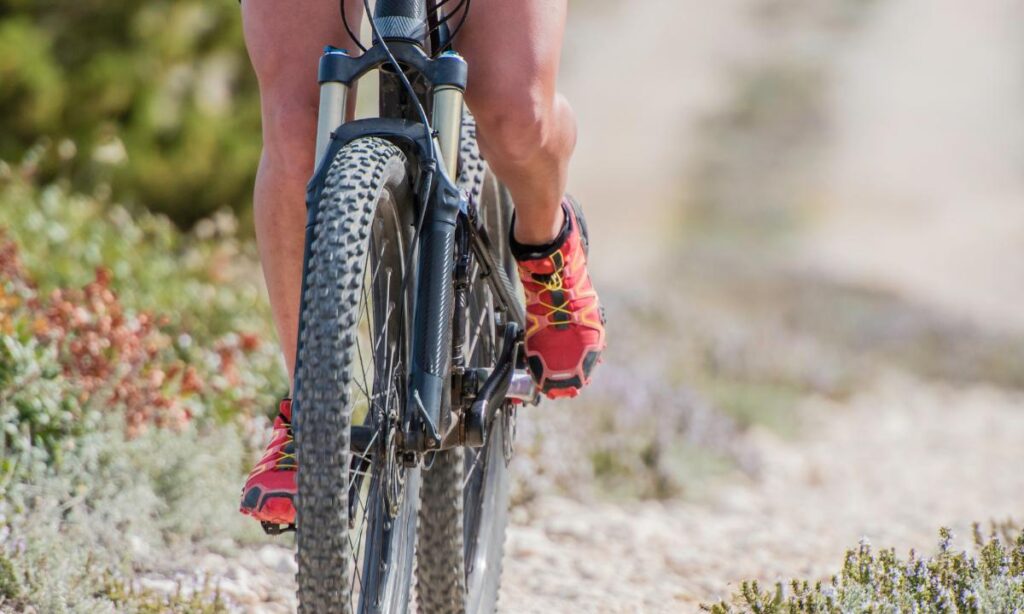 pernas de um ciclista em destaque ao andar de bicicleta