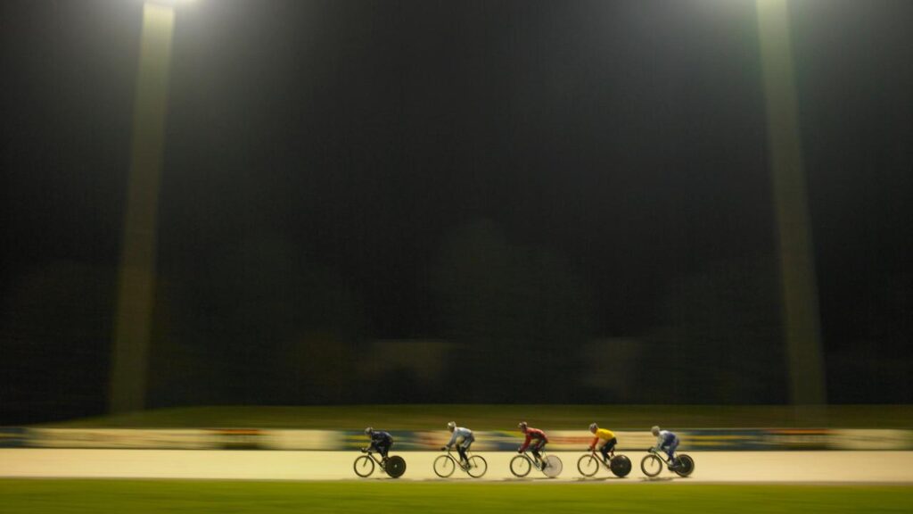 ciclistas pedalando a noite em grupo, em local específico