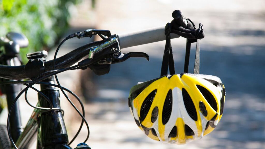 bicicleta com capacete pendurado no guidão, e demais equipamentos de segurança instalados