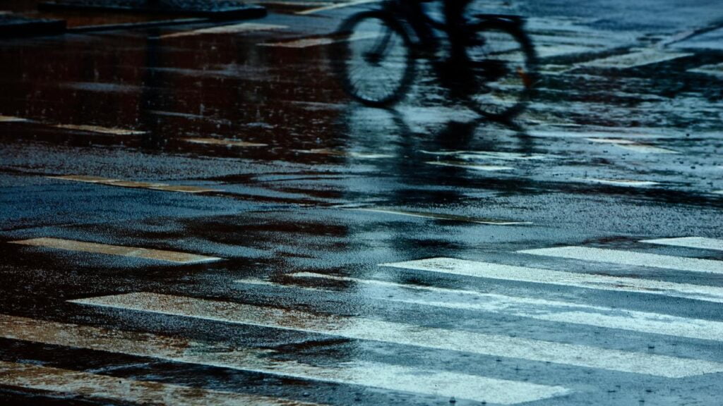 Pessoa indo pedalar em áreas urbanas com sua bike, na chuva.