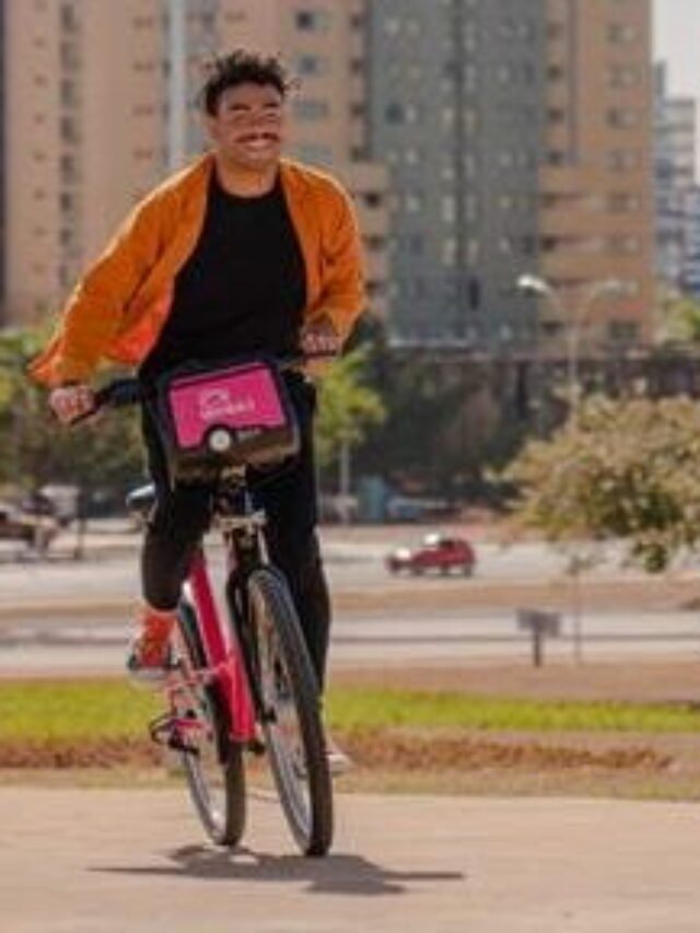 homem andando de bicicleta na praça.