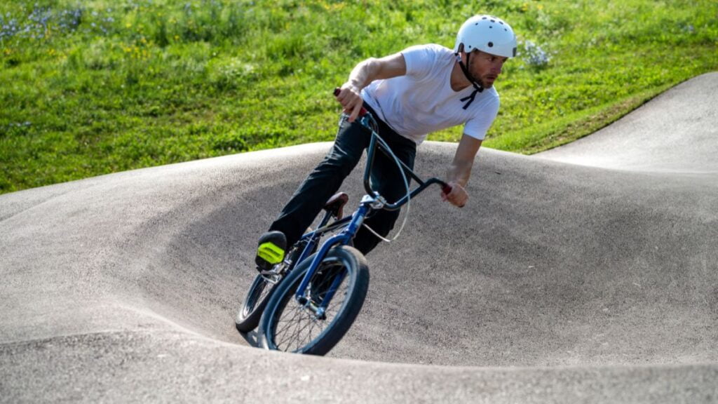 homem andando com uma bicicleta BMX