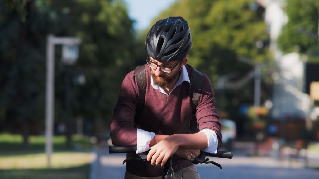 homem apoiado no guidão da bicicleta com roupa social